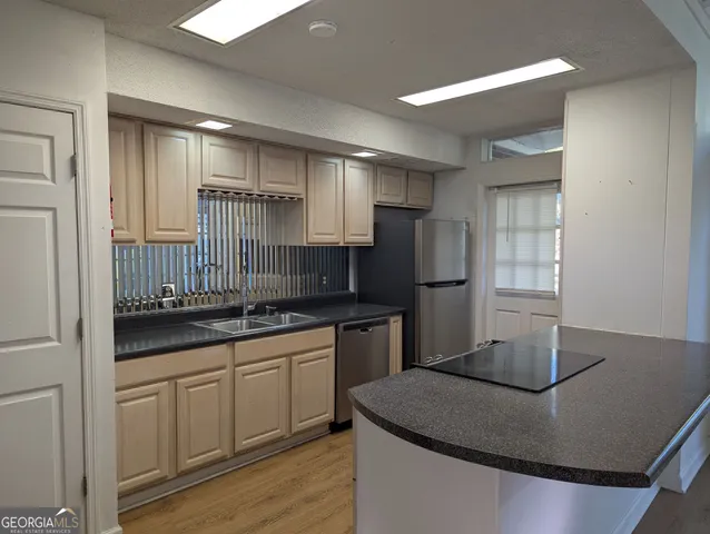 a kitchen with kitchen island granite countertop a sink stove and refrigerator