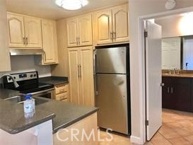 a kitchen with stainless steel appliances granite countertop a refrigerator a stove and a sink with granite countertops