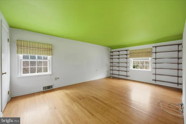 a view of a workspace with wooden floor and a window