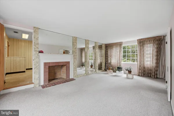 a view of an empty room with a fireplace and a window