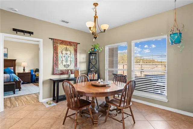 a dining room with furniture a chandelier and window