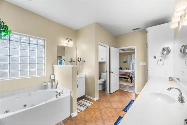 a bathroom with a tub a sink and a large mirror