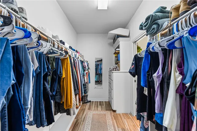 a view of walk in closet with clothes and shoes