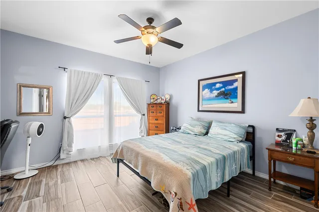 a bedroom with a large bed a chandelier and a window