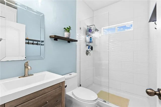 a bathroom with a sink a toilet and shower