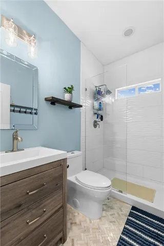 a bathroom with a sink a toilet and shower