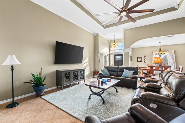a living room with furniture a flat screen tv and a potted plant