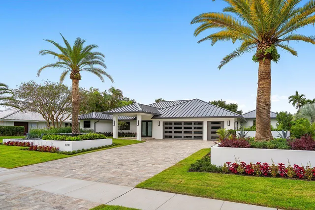 a kitchen with kitchen island granite countertop a sink and white cabinets with wooden floor
