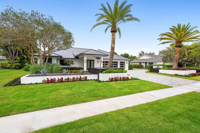 a kitchen with a stove a sink a kitchen island with chairs and wooden cabinets