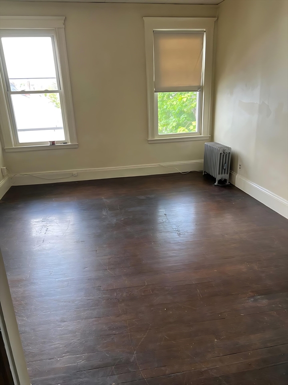71 Harwood Street, Unit 12 Lynn, MA 01902 - Photo 2 of 5 an empty room with wooden floor and windows