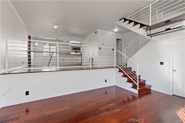 a view of a room with wooden floor and white walls