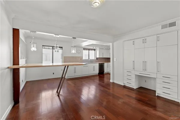 a view of a kitchen with wooden floor and electronic appliances