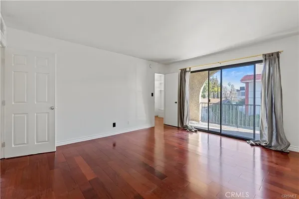 a view of an empty room with wooden floor