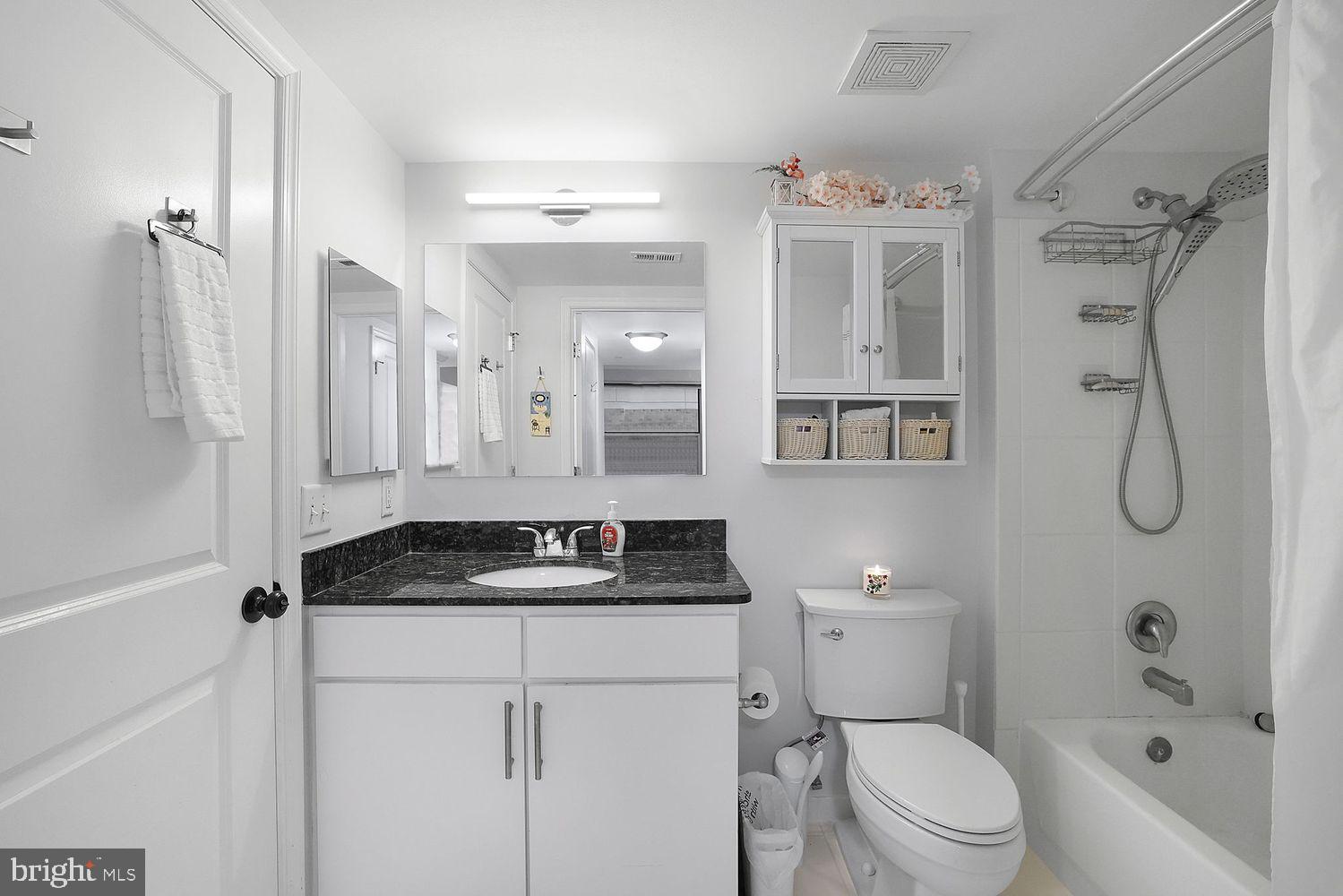 915 E Street Northwest, Unit 403 Washington, DC 20004 - Photo 17 of 30 a bathroom with a granite countertop sink a toilet and shower