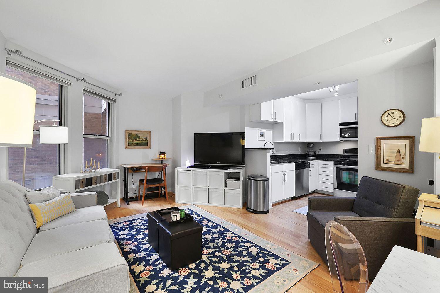 915 E Street Northwest, Unit 403 Washington, DC 20004 - Photo 2 of 30 a living room with furniture and a flat screen tv