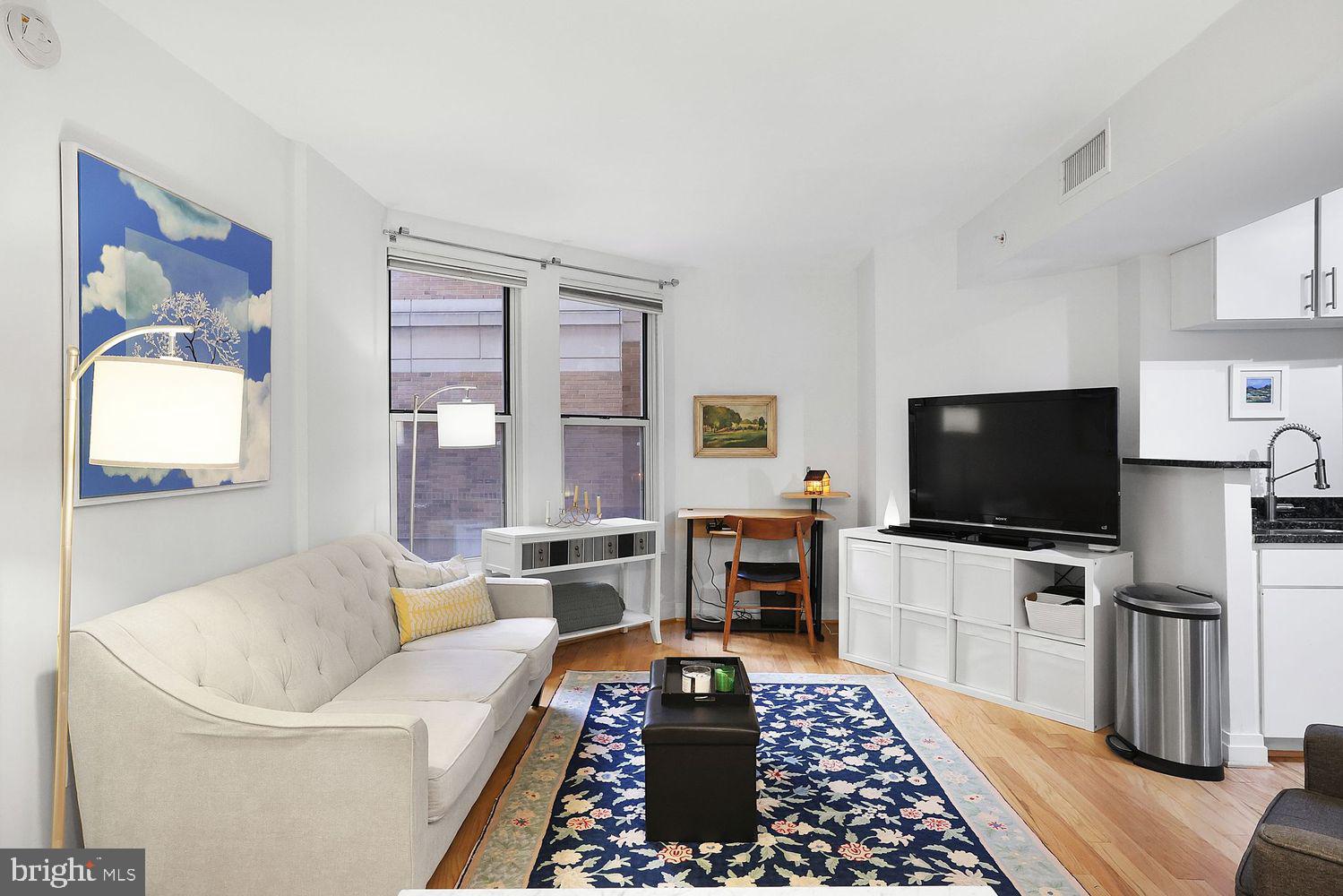 915 E Street Northwest, Unit 403 Washington, DC 20004 - Photo 3 of 30 a living room with furniture and a flat screen tv