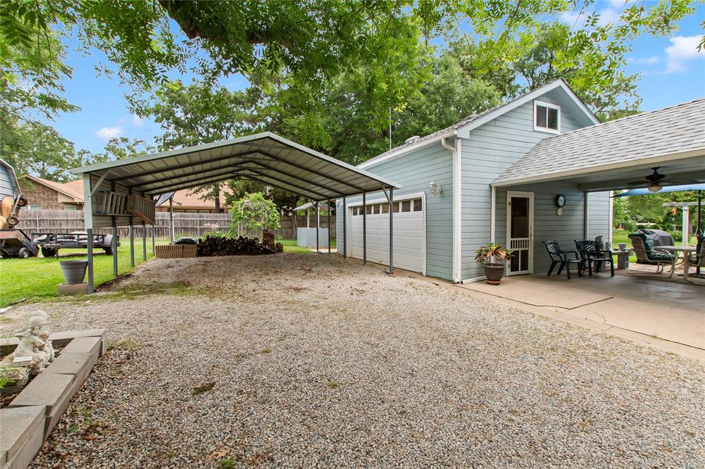 455 Stirrup Ranch Road Trinidad, TX 75163 - Photo 19 of 20 a view of a house with a yard and lawn chairs under an umbrella