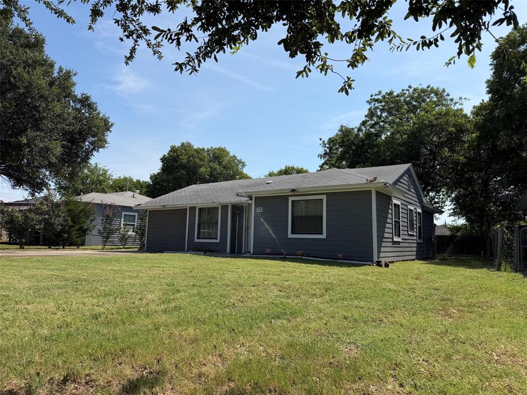 513 Shawnee Trace Grand Prairie, TX 75051 - Photo 2 of 32 Siding exterior with white trim, a covered entry, and a front lawn