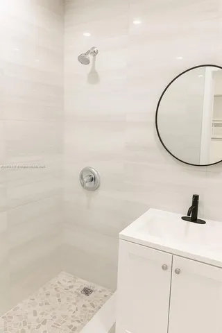 a bathroom with a sink a shower and a mirror