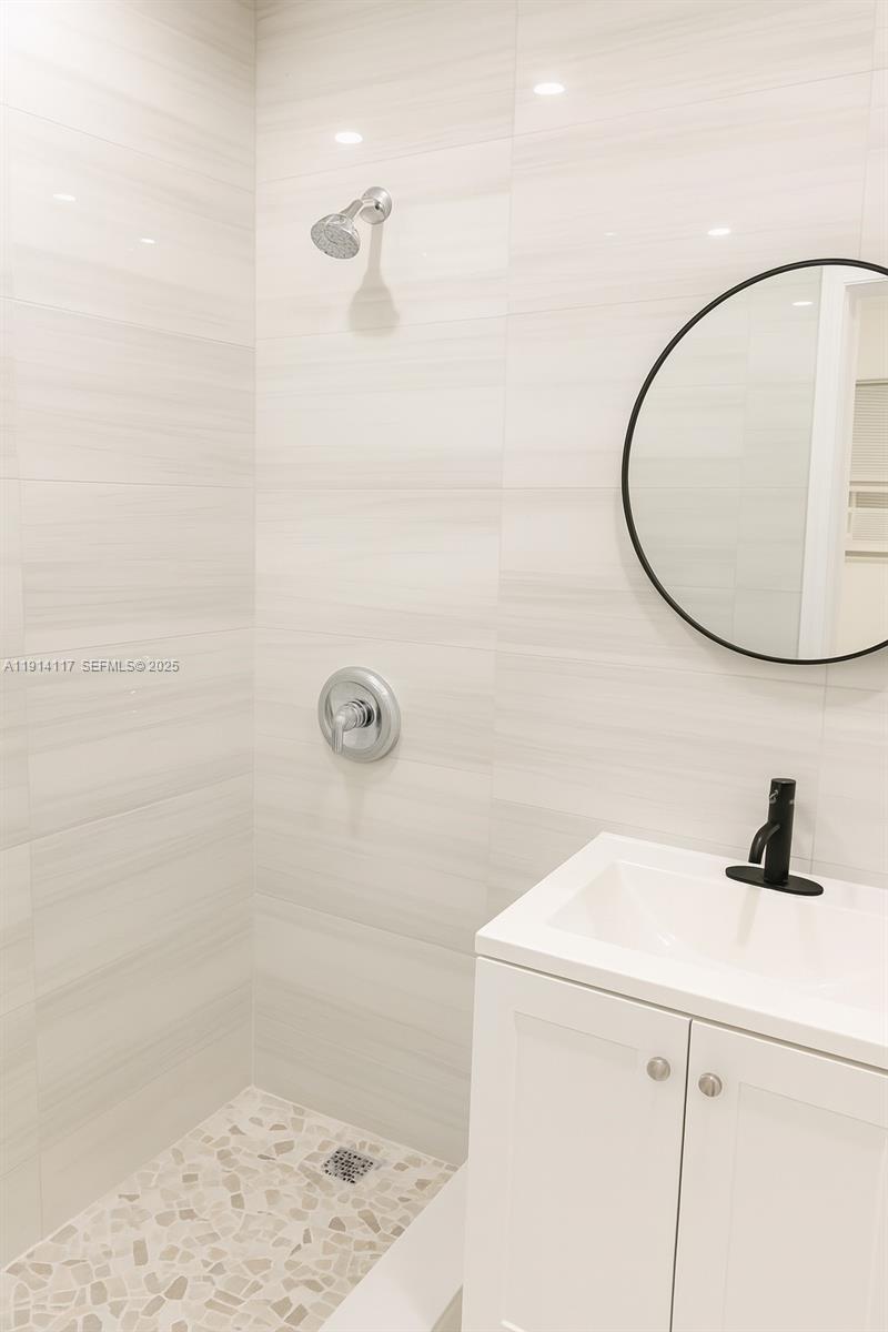 1046 Foster Road, Unit 1 Hallandale Beach, FL 33009 - Photo 8 of 8 a bathroom with a sink a shower and a mirror