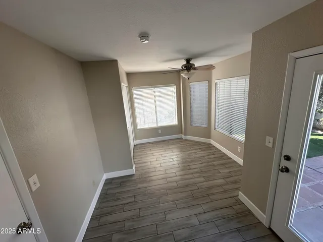 a view of hallway with window and wooden floor