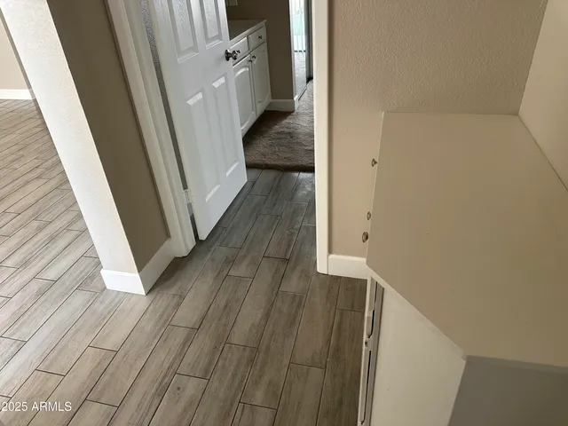 a view of a hallway with wooden floor and staircase