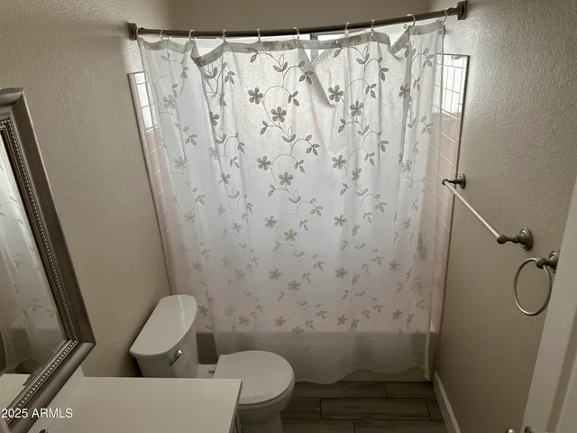 a bathroom with a toilet and a shower curtain