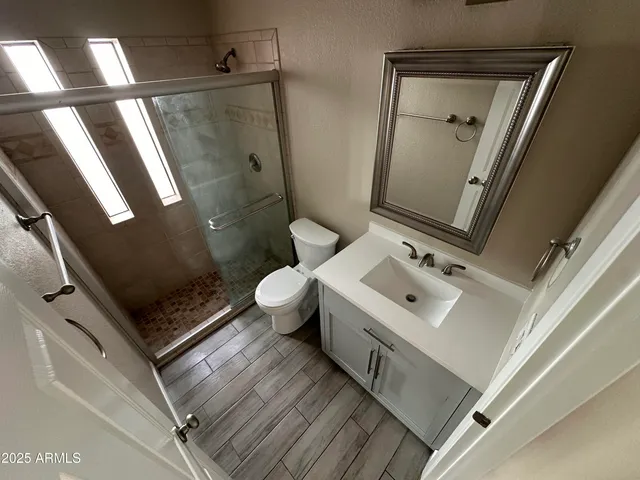 a bathroom with a sink mirror vanity and toilet
