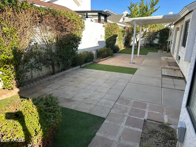 a view of a backyard with plants and a patio