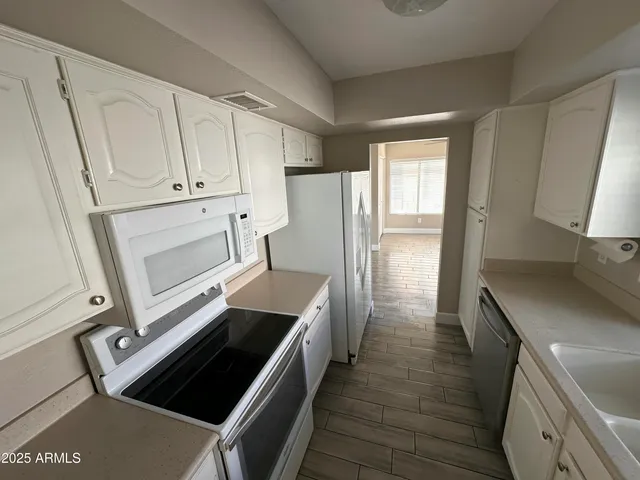 a kitchen with white cabinets and stainless steel appliances