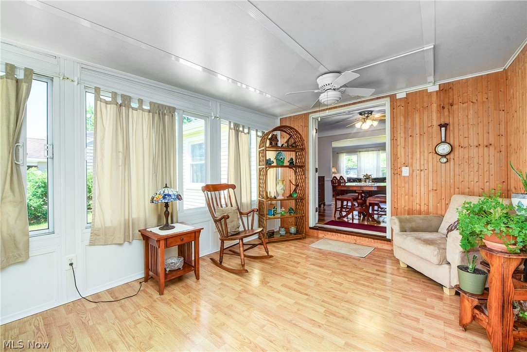 21399 Mastick Road Cleveland, OH 44126 - Photo 20 of 47 Sitting room featuring ceiling fan, wood walls, and hardwood / wood-style flooring