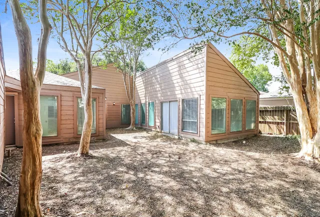a view of a house with a yard and floor to ceiling window