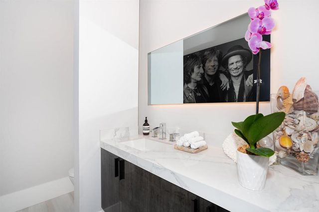 a bathroom with a sink a toilet a mirror and shower