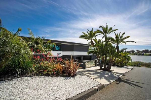 an aerial view of a residential houses with outdoor space and ocean view