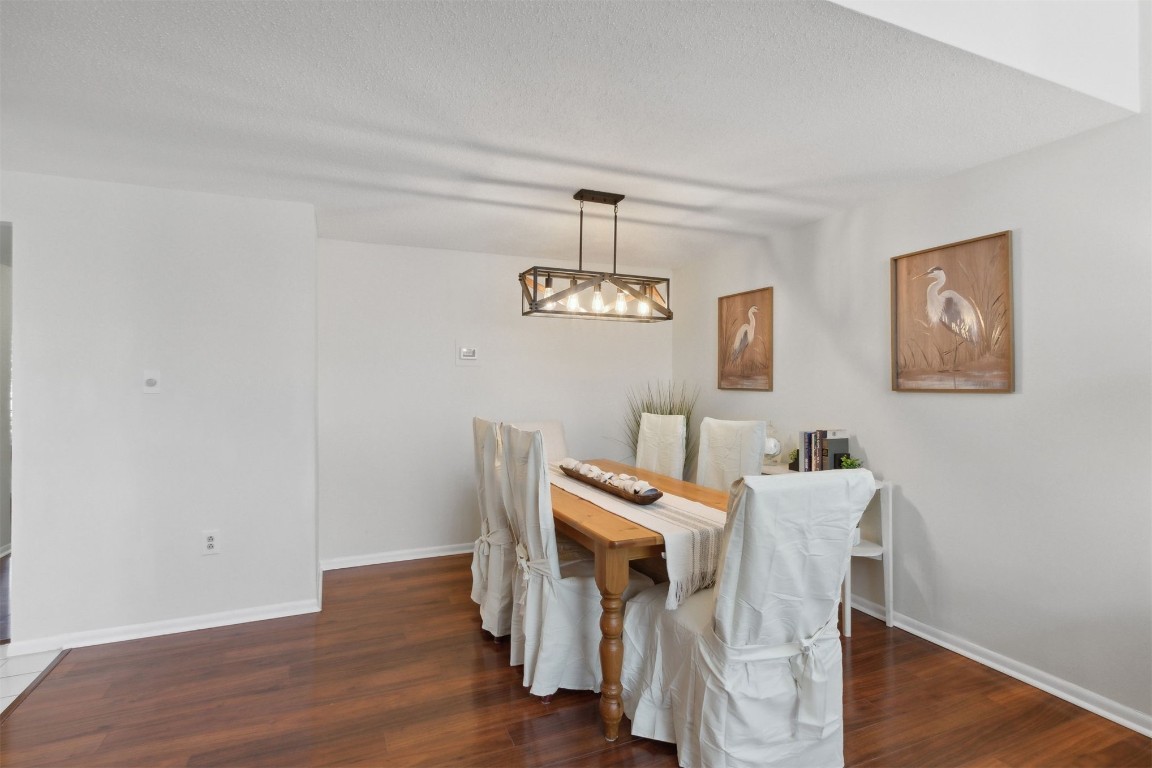 1163 Beach Walker Road, Unit 1163 Fernandina Beach, FL 32034 - Photo 12 of 52 a view of a dining room with furniture wooden floor and a chandelier