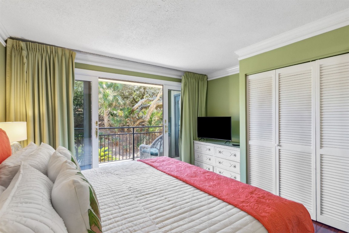 1163 Beach Walker Road, Unit 1163 Fernandina Beach, FL 32034 - Photo 18 of 52 a bedroom with a bed and a flat tv screen next to a window