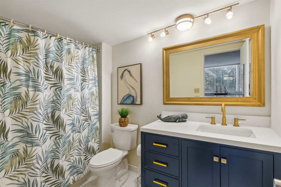 1163 Beach Walker Road, Unit 1163 Fernandina Beach, FL 32034 - Photo 32 of 52 a bathroom with a granite countertop toilet sink and mirror