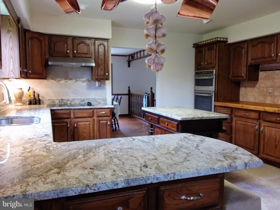 348 Eayrestown Road Southampton, NJ 08088 - Photo 9 of 32 a kitchen with kitchen island granite countertop wooden cabinets and a refrigerator