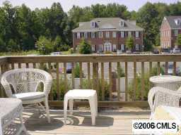 9127 Washam Potts Road, Unit 9127 Cornelius, NC 28031 - Photo 7 of 8 a view of a chair and table on the deck