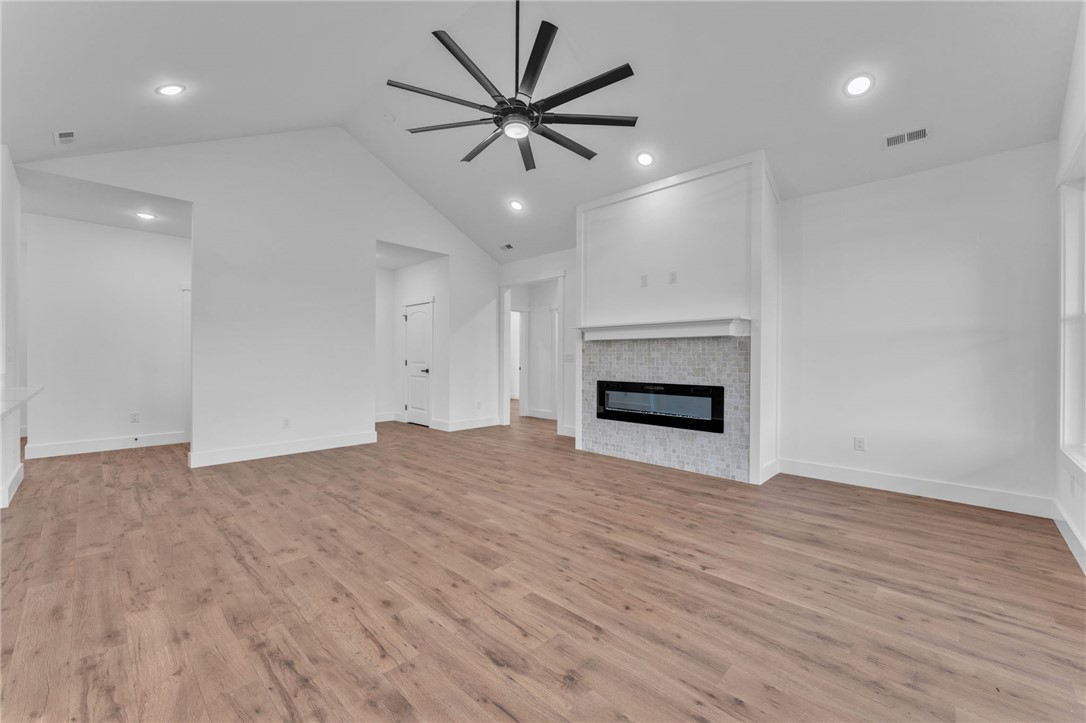 1725 Harris Bridge Road Anderson, SC 29621 - Photo 6 of 33 A spacious living area offers vaulted ceilings and an electric fireplace set in a mosaic tile surround.
