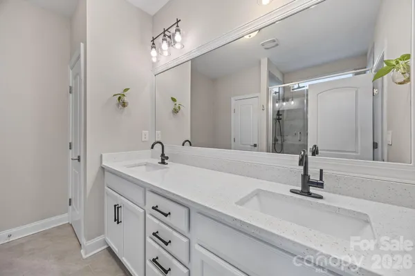 a bathroom with double vanity sink and a mirror