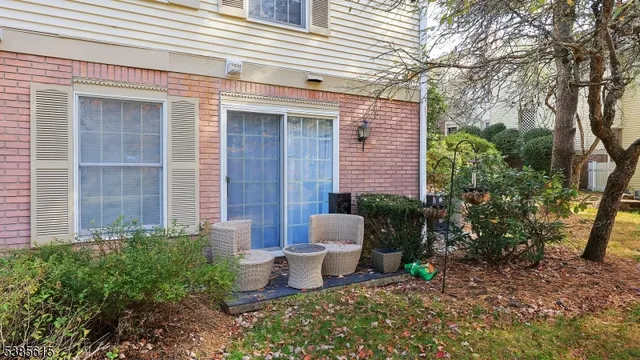 a view of a chair and table in backyard of the house