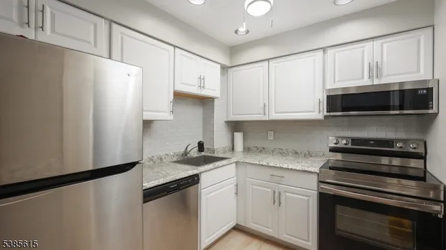 a kitchen with stainless steel appliances a refrigerator sink and cabinets
