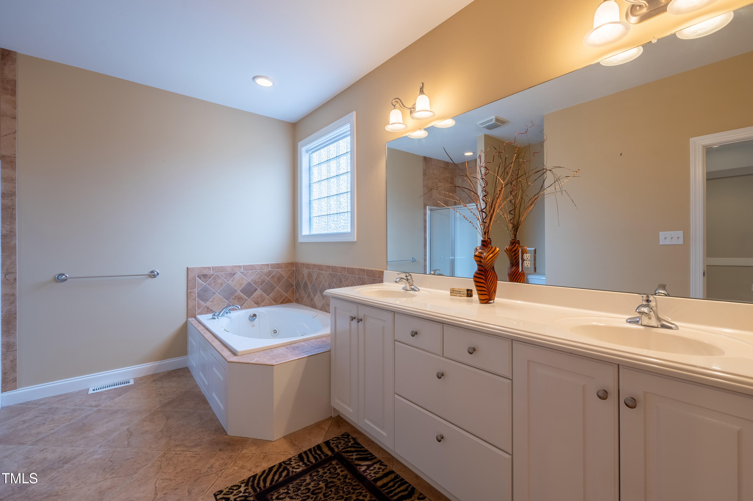 5148 Nowell Road Sims, NC 27880 - Photo 29 of 49 a bathroom with a double vanity sink a mirror and a bathtub