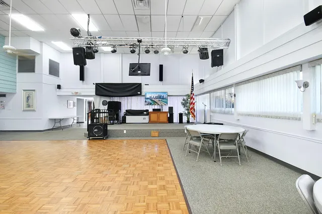 a room with stainless steel appliances lots of white furniture a chandelier a stove and a kitchen view