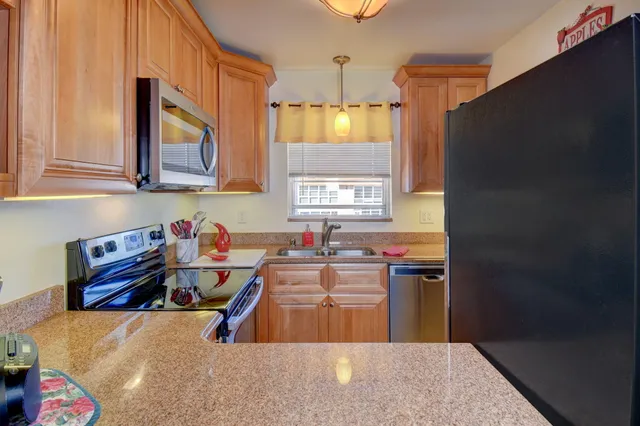 a kitchen with stainless steel appliances a sink a stove and a refrigerator