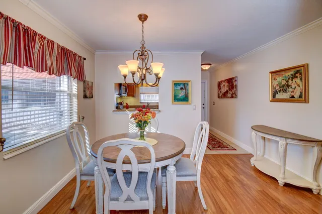 a view of a dining room with furniture a chandelier and wooden floor