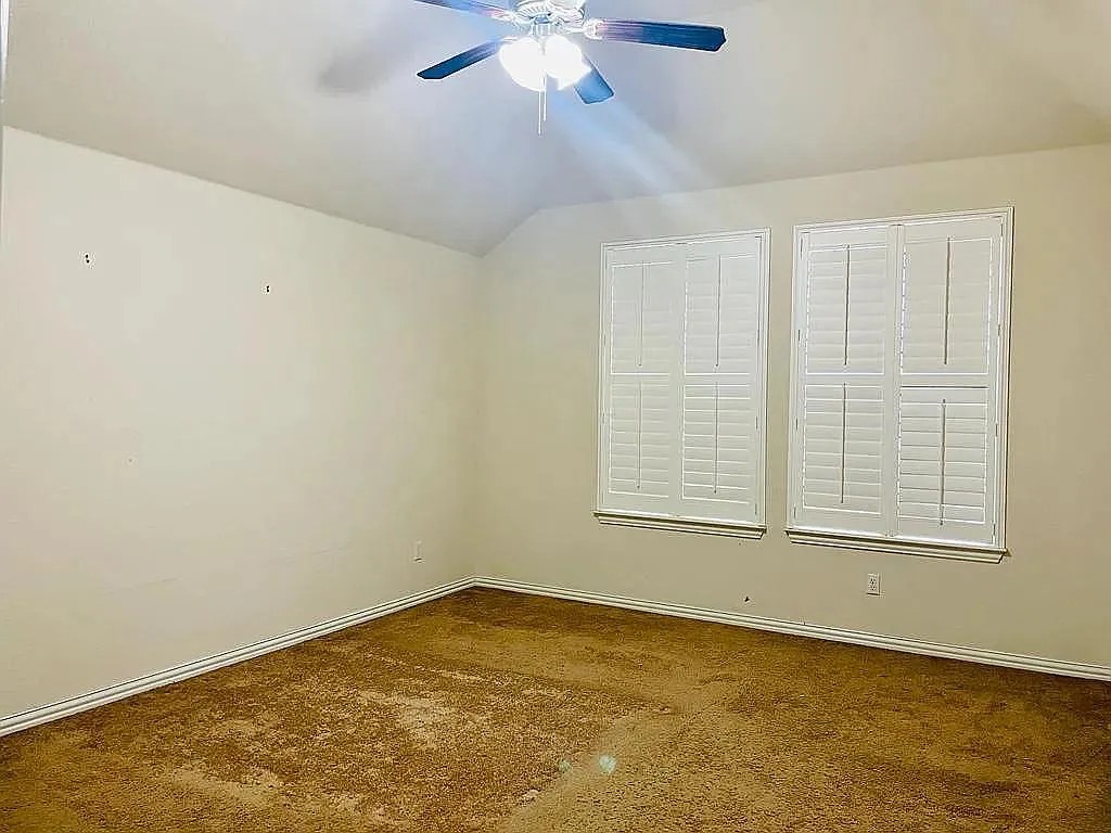 616 Garner Park Drive Georgetown, TX 78628 - Photo 18 of 26 Spare room featuring a ceiling fan, lofted ceiling, and dark colored carpet