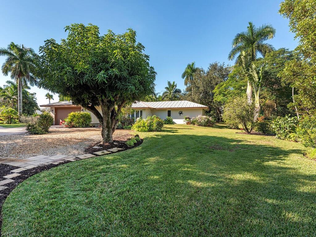 725 Pectin Road Naples, FL 34102 - Photo 2 of 13 Large well-landscaped lot has ample parking in the rear to the East, and an enclosed two car garage.