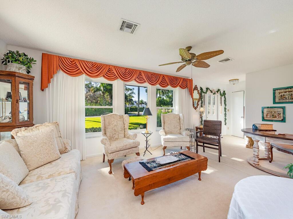 725 Pectin Road Naples, FL 34102 - Photo 5 of 13 Original formal living room with landscaped view accessible from front foyer entrance or from side two car garage. White carpet throughout. Beautifully maintained home.